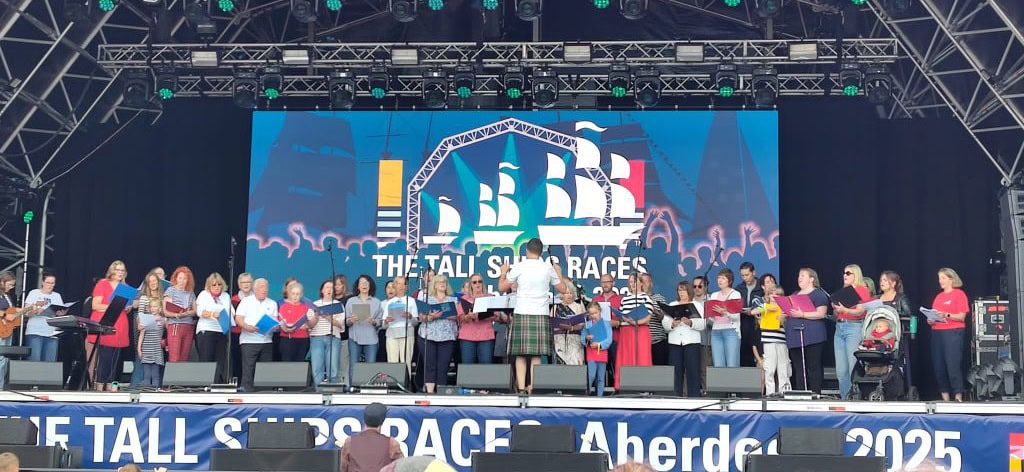 Group of tall individuals performing on stage at ACE Voices 2024 event.