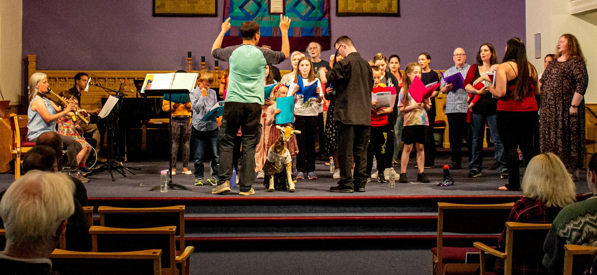 Community choir performing on stage during a concert.
