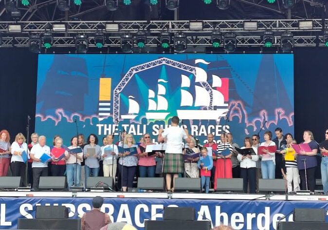 Group of tall individuals performing on stage at ACE Voices 2024 event.